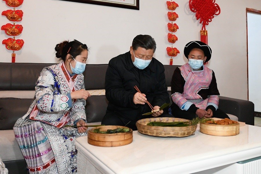 2021年2月3日下午，習(xí)近平在貴州畢節(jié)市黔西縣新仁苗族鄉(xiāng)化屋村苗族村民趙玉學(xué)家，同一家人邊聊家常邊制作當(dāng)?shù)貍鹘y(tǒng)節(jié)日食品黃粑。新華社記者 李學(xué)仁 攝